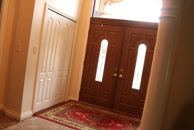 foyer with decorative columns and a wealth of natural light