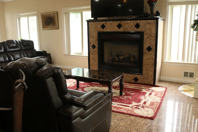 living room with a high end fireplace, carpet, and plenty of natural light