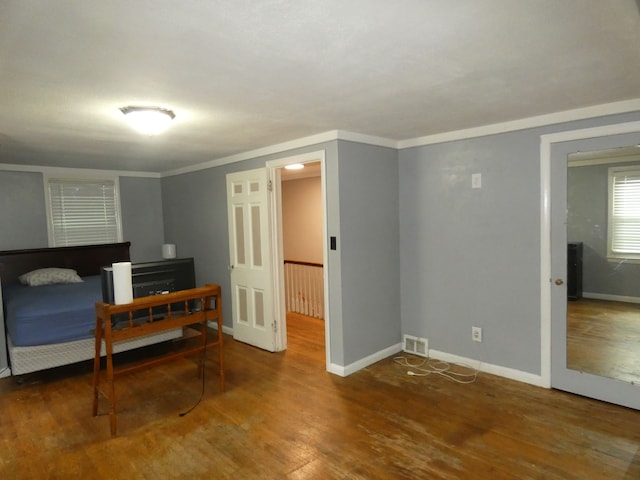 bedroom with crown molding and hardwood / wood-style flooring