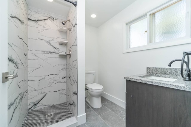 bathroom with a marble finish shower, baseboards, toilet, and vanity