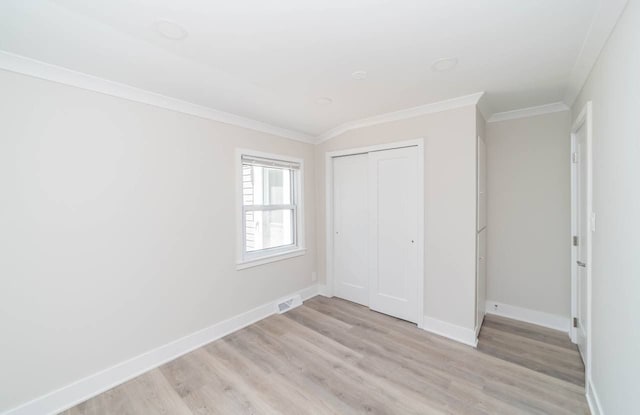 unfurnished bedroom with visible vents, baseboards, a closet, crown molding, and light wood-type flooring