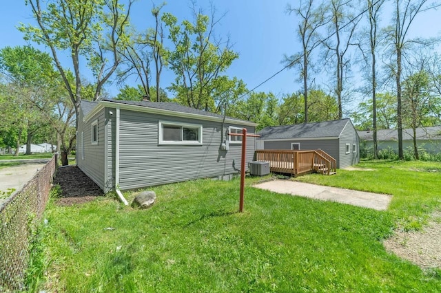 exterior space featuring a deck, cooling unit, and a yard