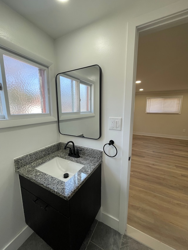 bathroom featuring baseboards, wood finished floors, and vanity