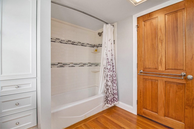 bathroom featuring wood-type flooring and shower / bath combination with curtain