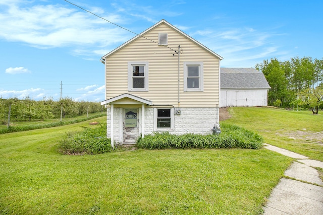 rear view of property featuring a lawn