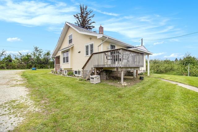 rear view of house featuring a deck and a yard