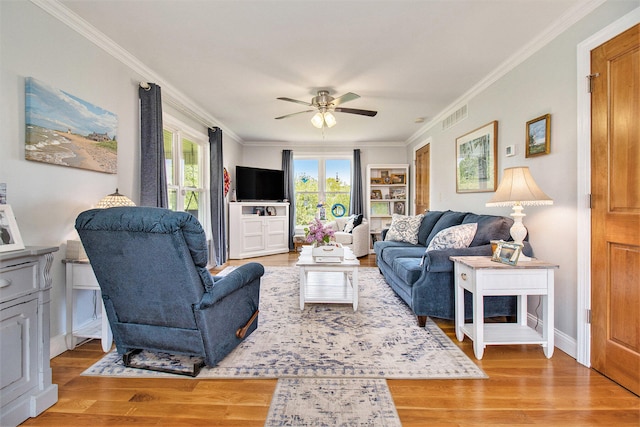 living room featuring crown molding, light hardwood / wood-style flooring, and ceiling fan