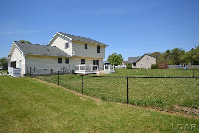 rear view of property featuring a wooden deck and a yard