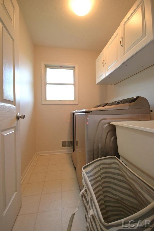 laundry room with cabinets, sink, separate washer and dryer, and light tile patterned flooring