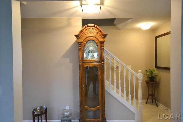 stairs featuring a textured ceiling