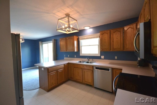 kitchen featuring sink, kitchen peninsula, stainless steel appliances, and an inviting chandelier