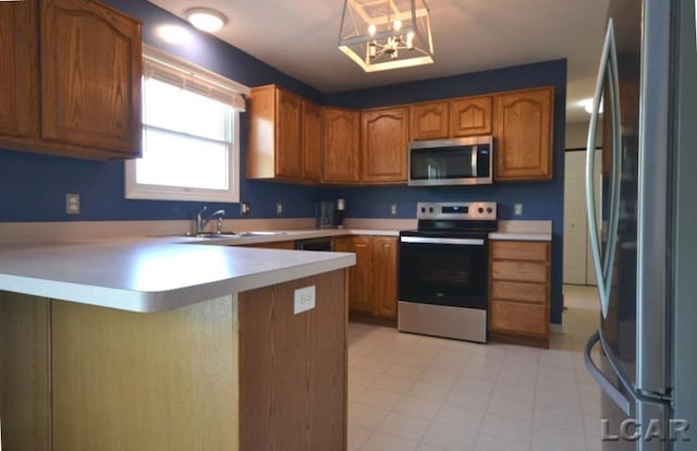 kitchen with sink, a notable chandelier, kitchen peninsula, pendant lighting, and appliances with stainless steel finishes