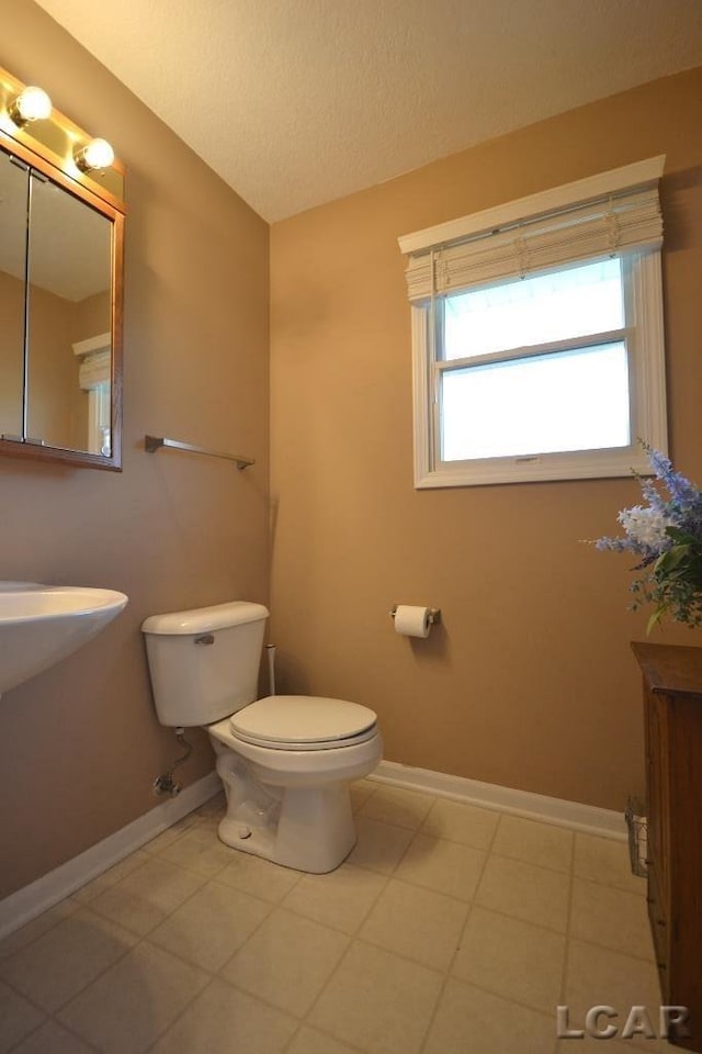 bathroom featuring tile patterned flooring, a textured ceiling, and toilet