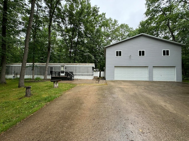 view of side of home with a yard, a garage, and a wooden deck