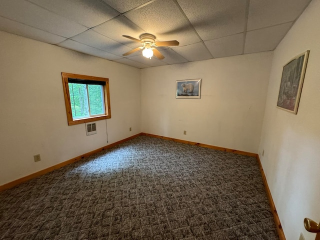 unfurnished room with carpet flooring, a paneled ceiling, ceiling fan, and heating unit