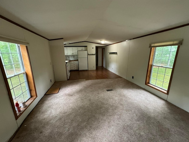 unfurnished living room with lofted ceiling, dark wood-type flooring, plenty of natural light, and ornamental molding