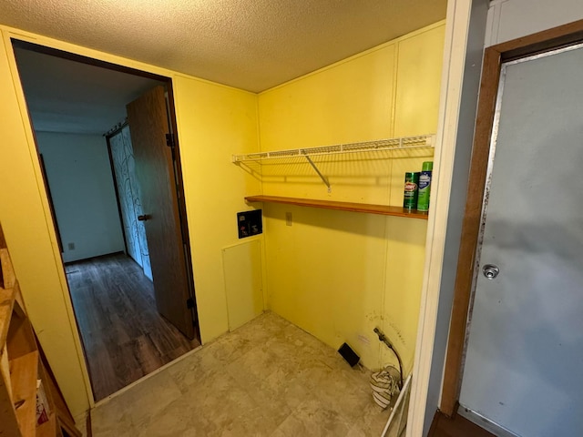 laundry area featuring dark wood-type flooring and a textured ceiling