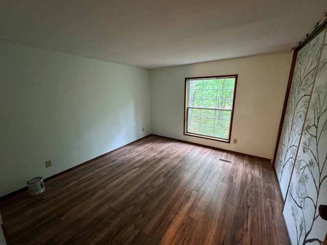 empty room with dark hardwood / wood-style flooring