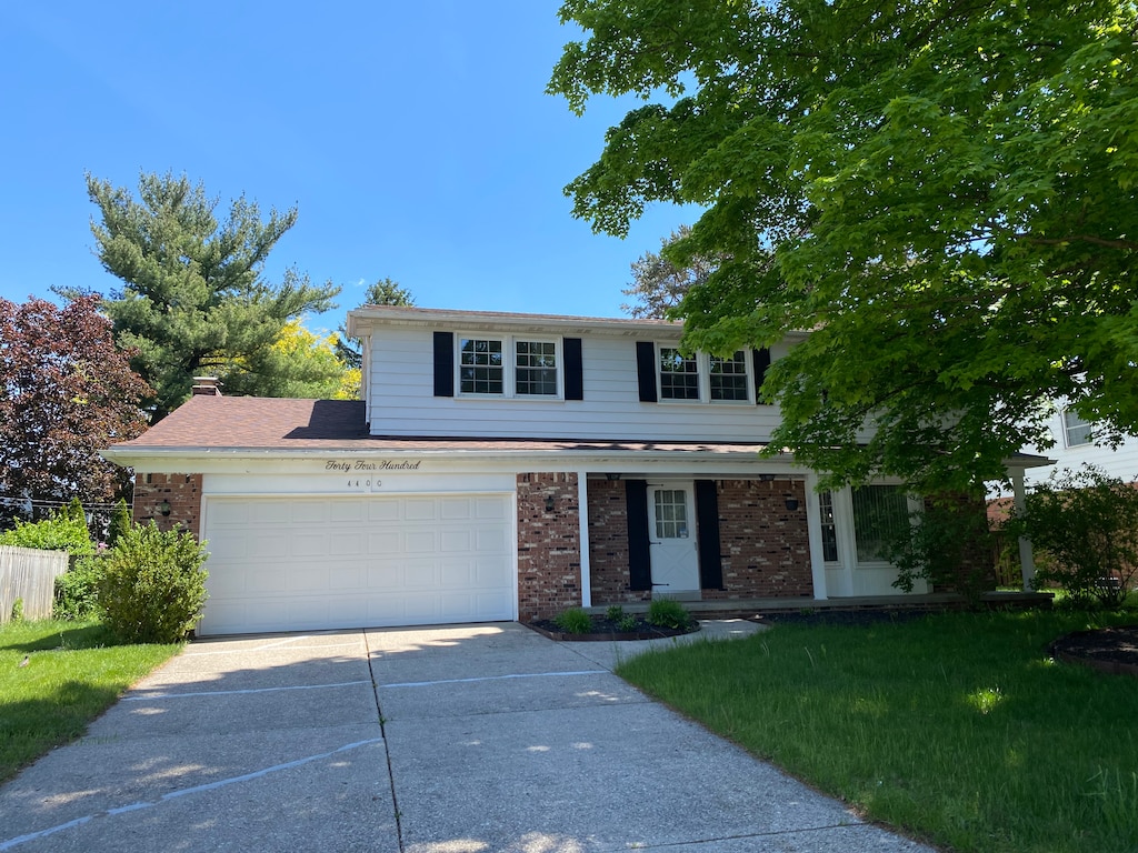 view of front of property with a garage and a front lawn