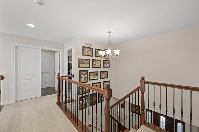 hallway featuring a chandelier and light colored carpet