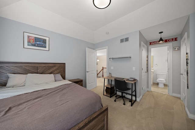 carpeted bedroom featuring ensuite bath