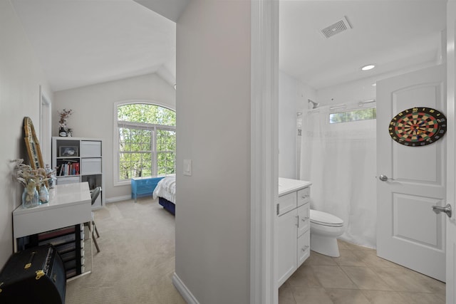 bathroom with tile patterned floors, toilet, a shower, and vaulted ceiling