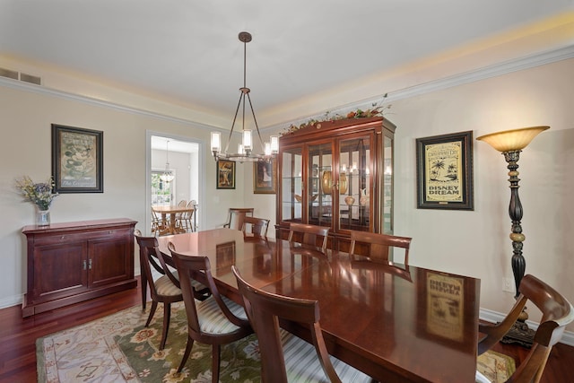 dining area featuring hardwood / wood-style flooring, a notable chandelier, and ornamental molding