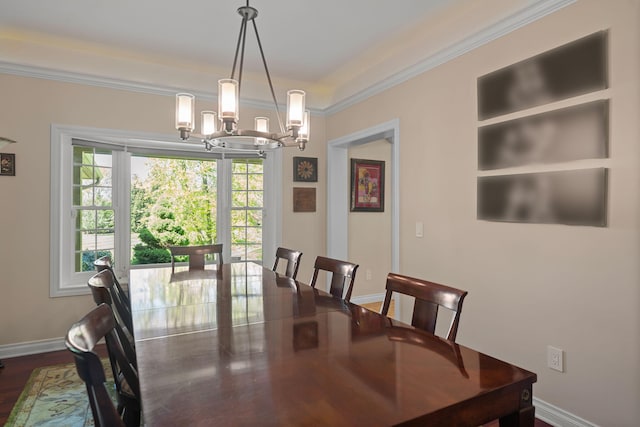 dining room with dark hardwood / wood-style flooring, ornamental molding, and a notable chandelier