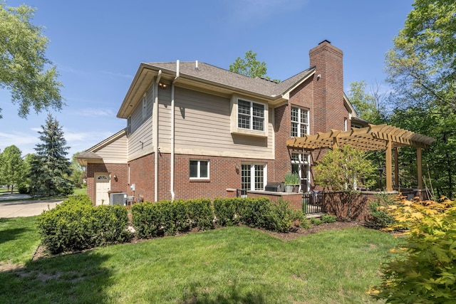 back of house with a yard and a pergola