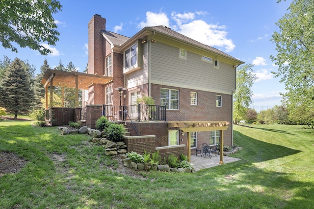 rear view of house featuring a lawn, a pergola, and a patio