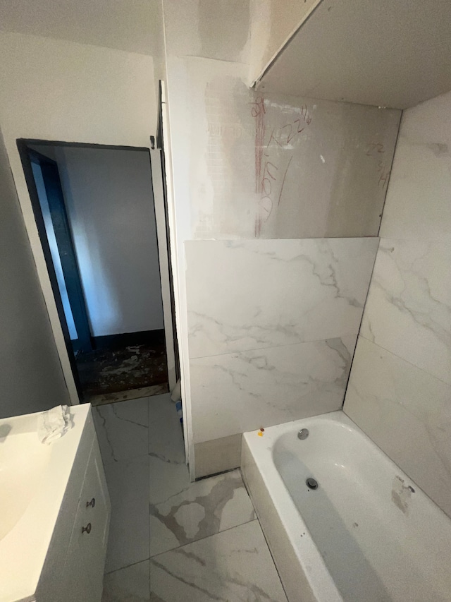 bathroom featuring a washtub and vanity