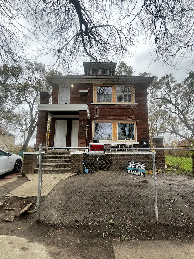 american foursquare style home featuring a fenced front yard and a gate