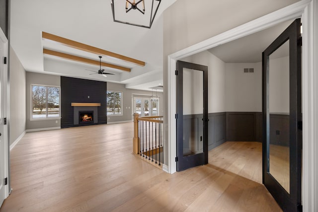 35873 Glenville Dr, New Baltimore, MI 48047 - foyer with a fireplace, light wood finished floors, visible vents, and ceiling fan with notable chandelier