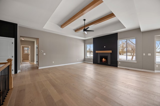 35873 Glenville Dr, New Baltimore, MI 48047 - unfurnished living room featuring a raised ceiling, a healthy amount of sunlight, and ceiling fan