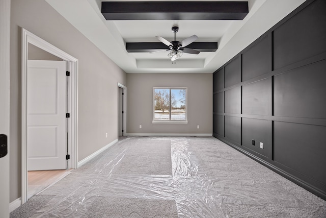 empty room featuring a tray ceiling and ceiling fan