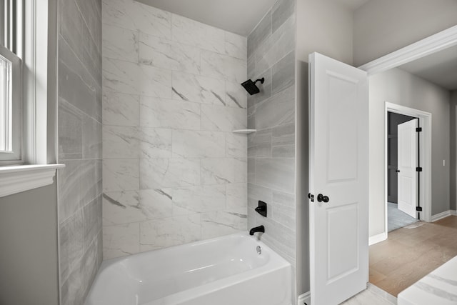 bathroom with hardwood / wood-style flooring and tiled shower / bath combo