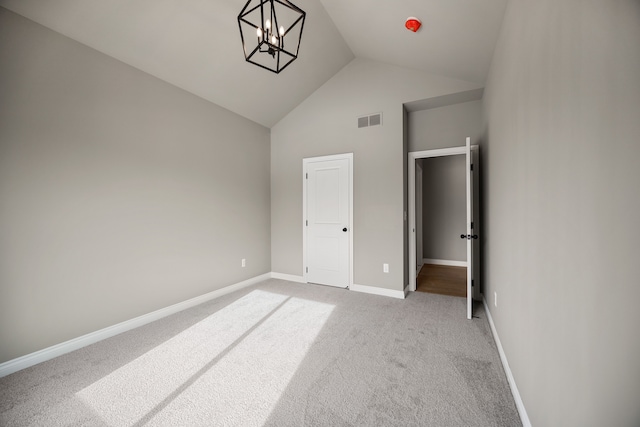 unfurnished bedroom featuring high vaulted ceiling, light colored carpet, and a chandelier