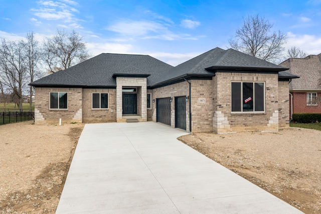 35873 Glenville Dr, New Baltimore, MI 48047 - prairie-style home featuring a garage, fence, concrete driveway, brick siding, and roof with shingles
