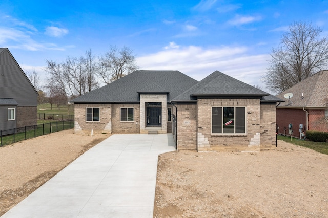 35873 Glenville Dr, New Baltimore, MI 48047 - prairie-style house featuring concrete driveway, a shingled roof, fence, and brick siding