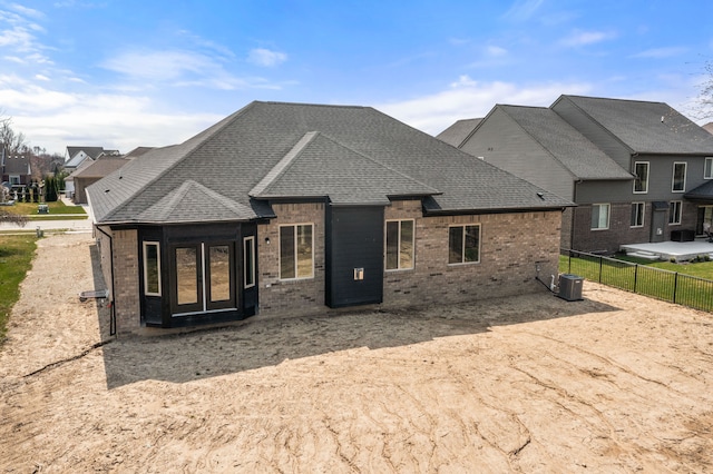 35873 Glenville Dr, New Baltimore, MI 48047 - back of house featuring central AC, a shingled roof, fence, and brick siding