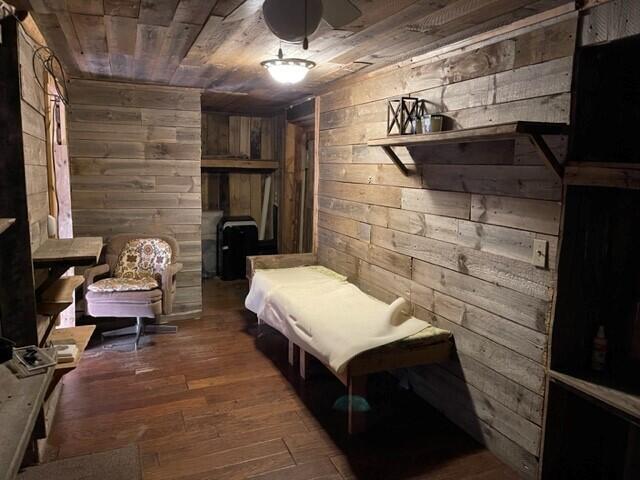 bedroom featuring dark hardwood / wood-style flooring, wooden ceiling, and wooden walls