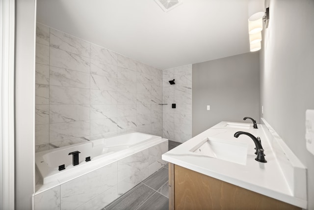 bathroom with vanity and a relaxing tiled tub