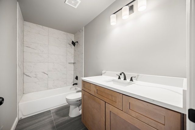 full bathroom featuring vanity, tiled shower / bath combo, and toilet