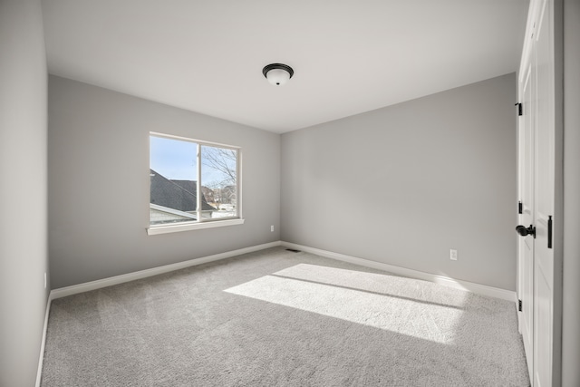 spare room featuring light carpet