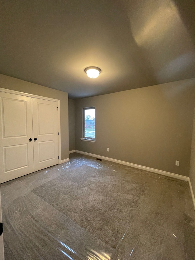 unfurnished bedroom featuring carpet and a closet