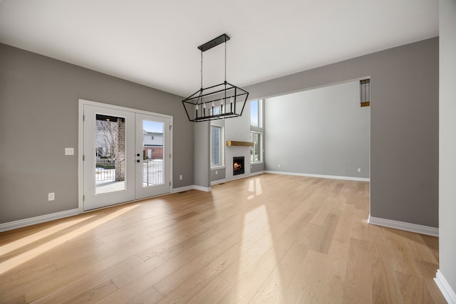 unfurnished living room featuring light hardwood / wood-style floors and french doors