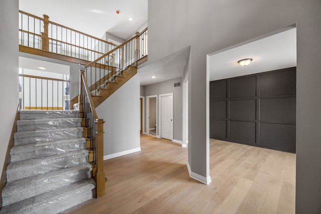 stairway featuring hardwood / wood-style floors and a high ceiling