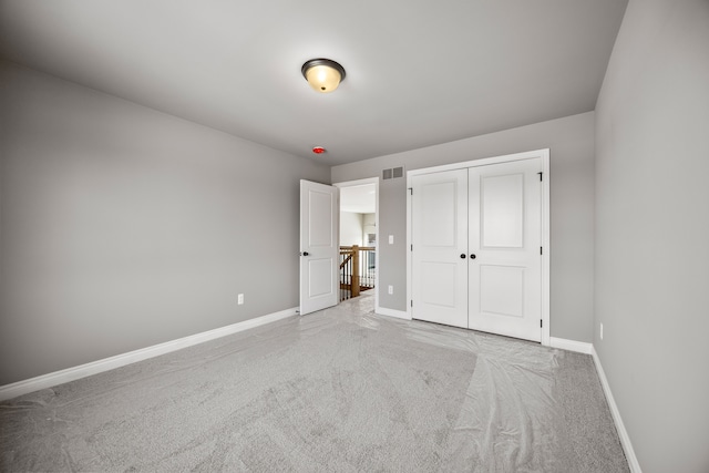 unfurnished bedroom with a closet and light carpet