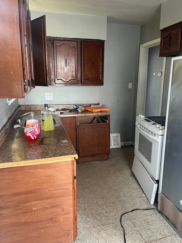 kitchen with visible vents, electric stove, dark brown cabinets, light floors, and dark countertops