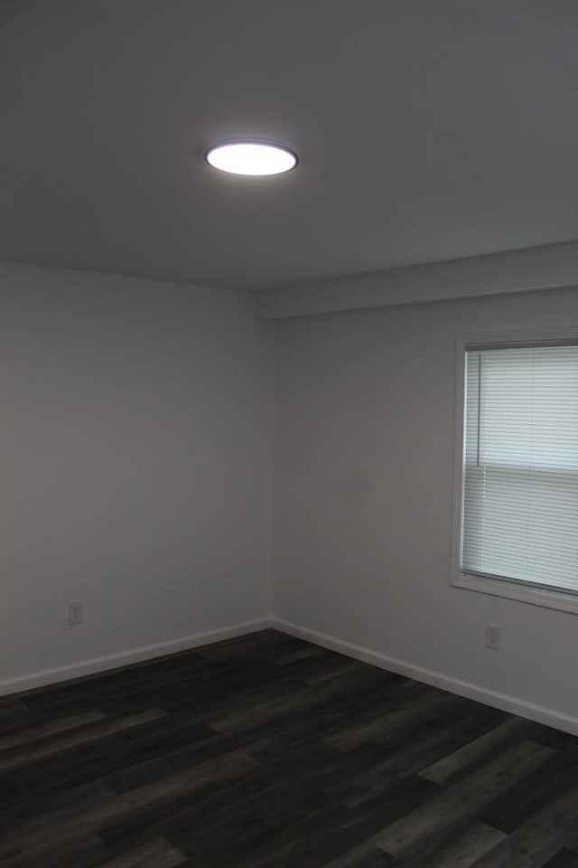 spare room with dark hardwood / wood-style flooring